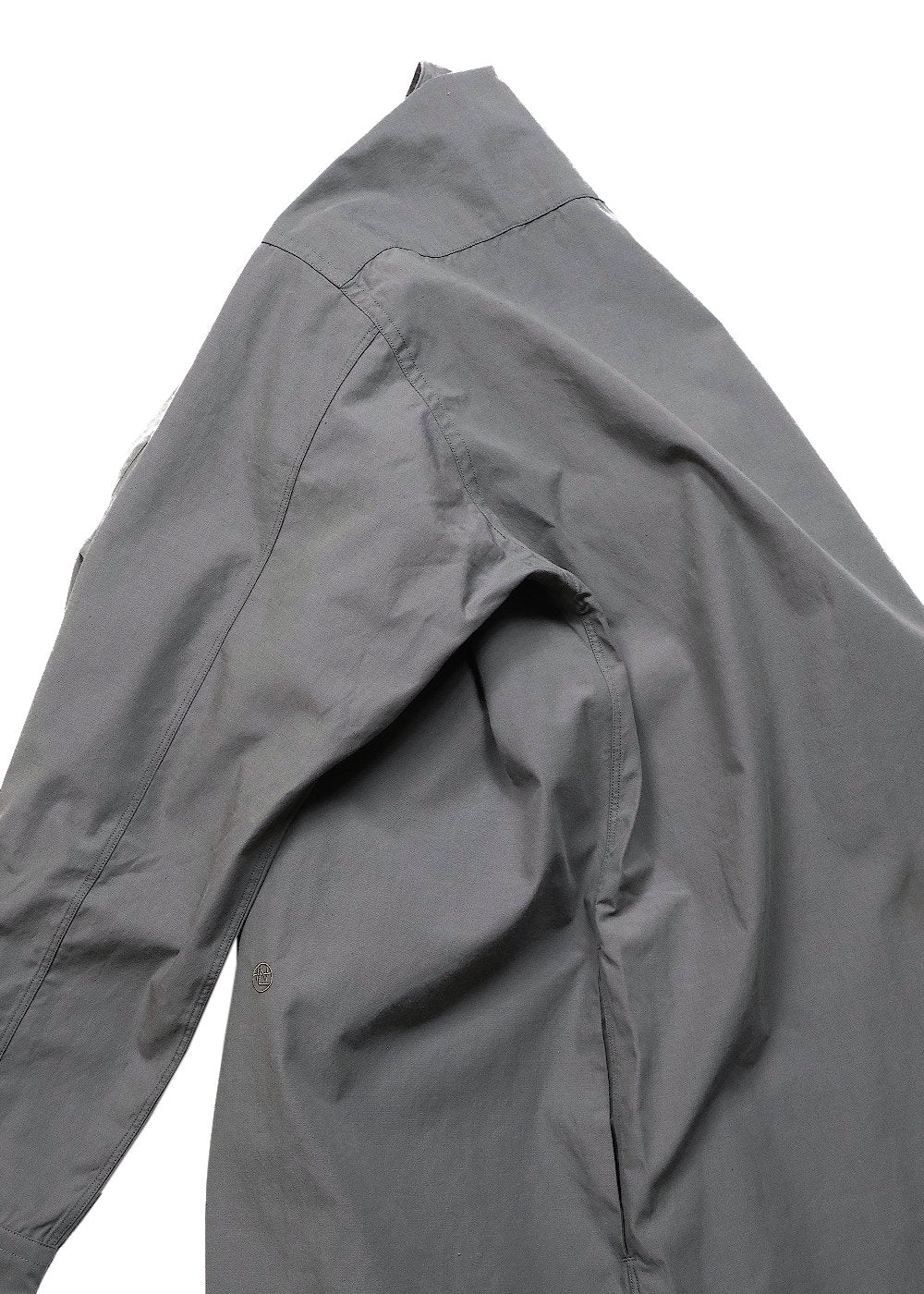 A close-up of a dark gray long-sleeve shirt or jacket, showing the shoulder, collar, and fabric texture against a plain white background.